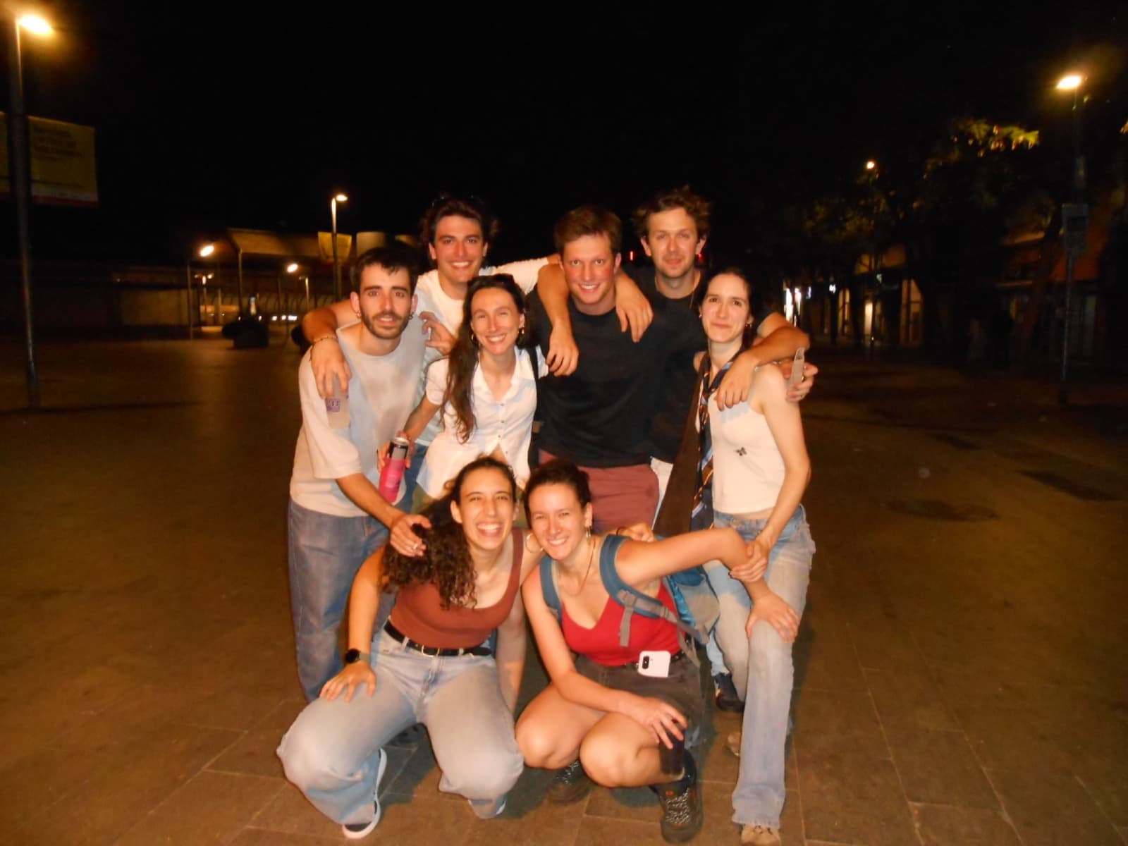 Els vuit membres de Nibrot abraçats en una plaça de nit
